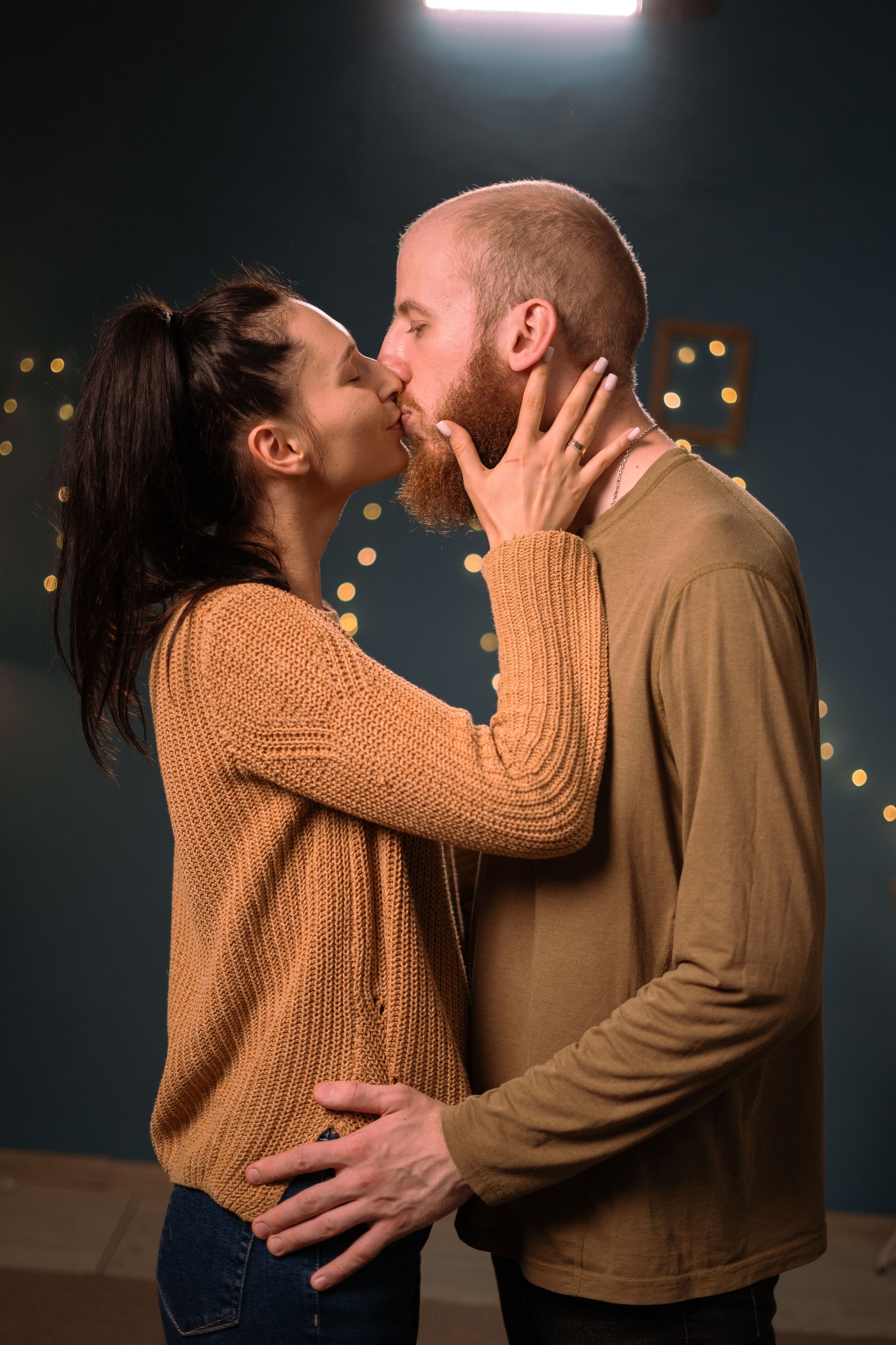 Couple in love kissing at night standing in living room. Concept of love, romance and passion